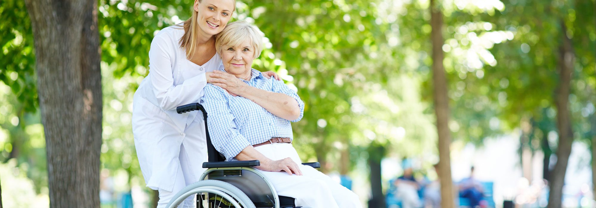 Carer - Woman In White Shirt Assisting Lady In Wheelchair